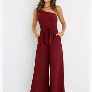 NWOT. Chic one-shoulder jumpsuit w/pockets and tie at the waist. Size Medium